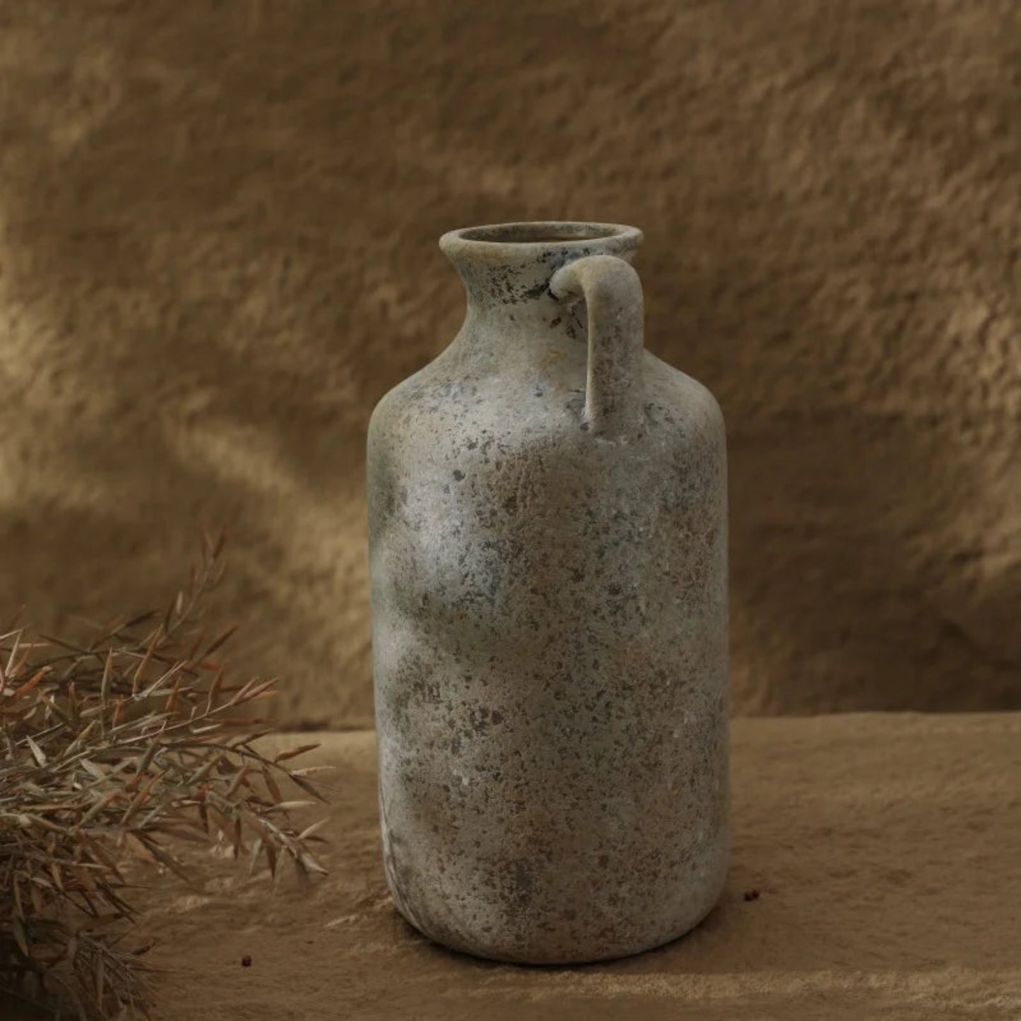 Vintage ceramic jar with a handle on a textured brown background
