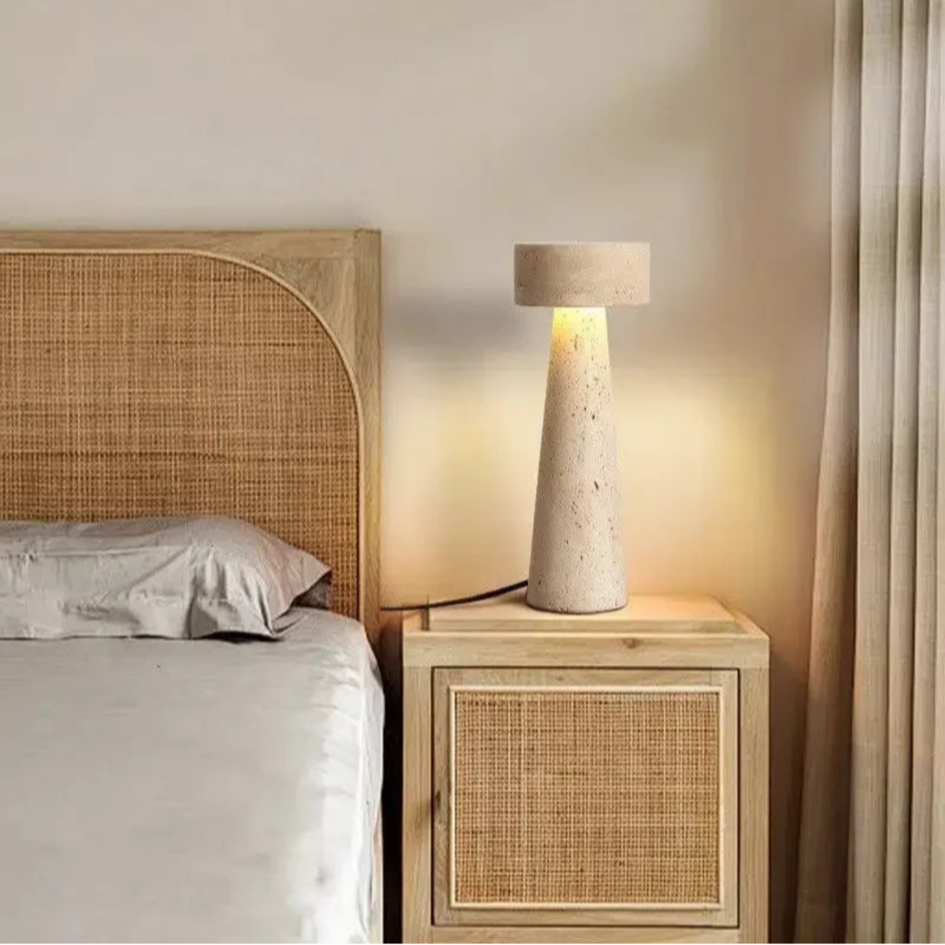 Bedroom with rattan headboard and stone-textured lamp on wooden nightstand