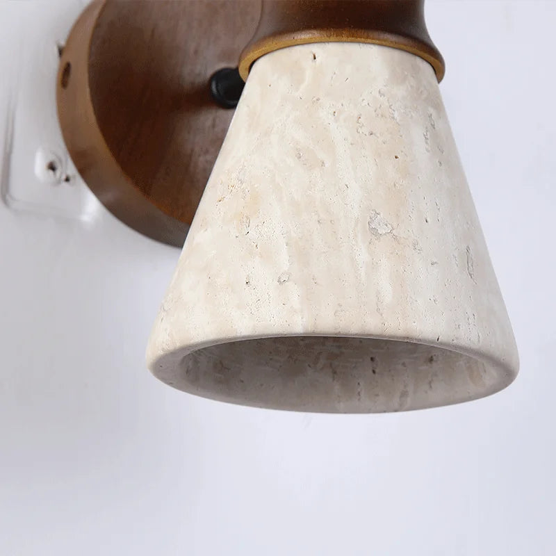 Wall-mounted light fixture with a beige stone-like shade and brown metal base on a white background