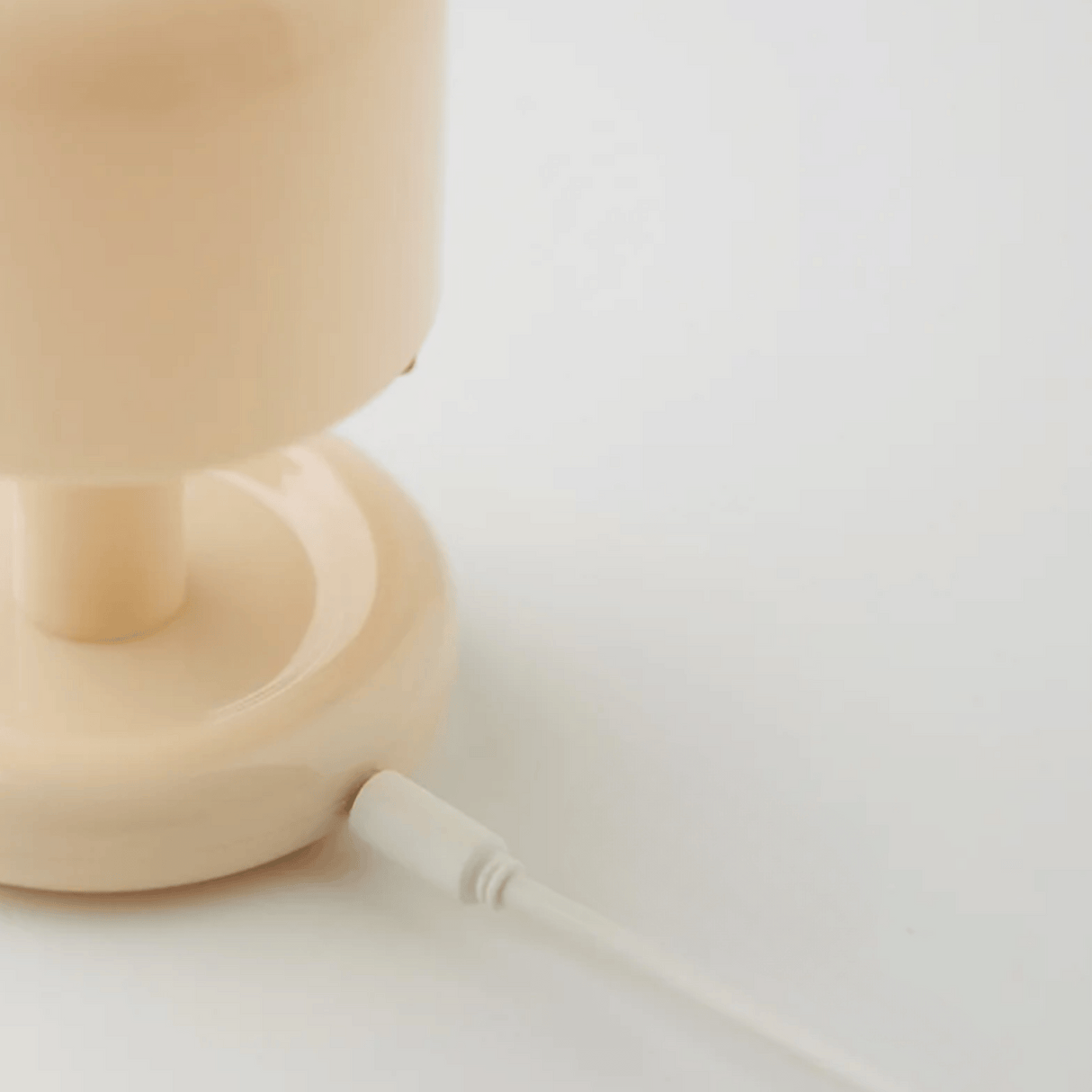 Beige lamp on a white surface with a blurred background