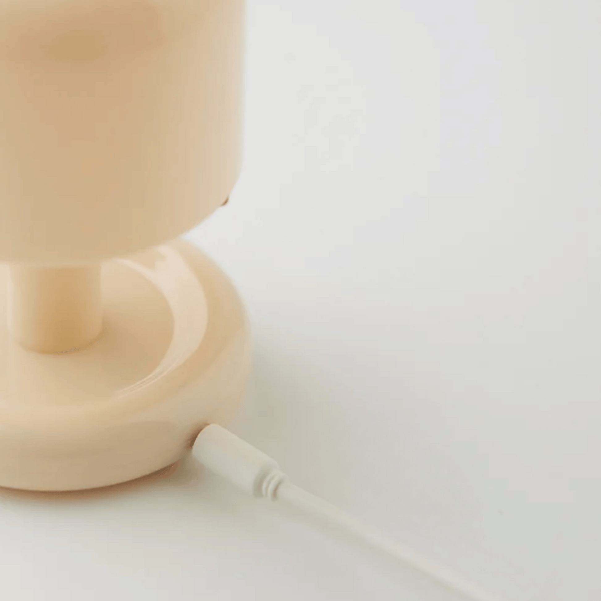 Beige lamp on a white surface with a blurred background