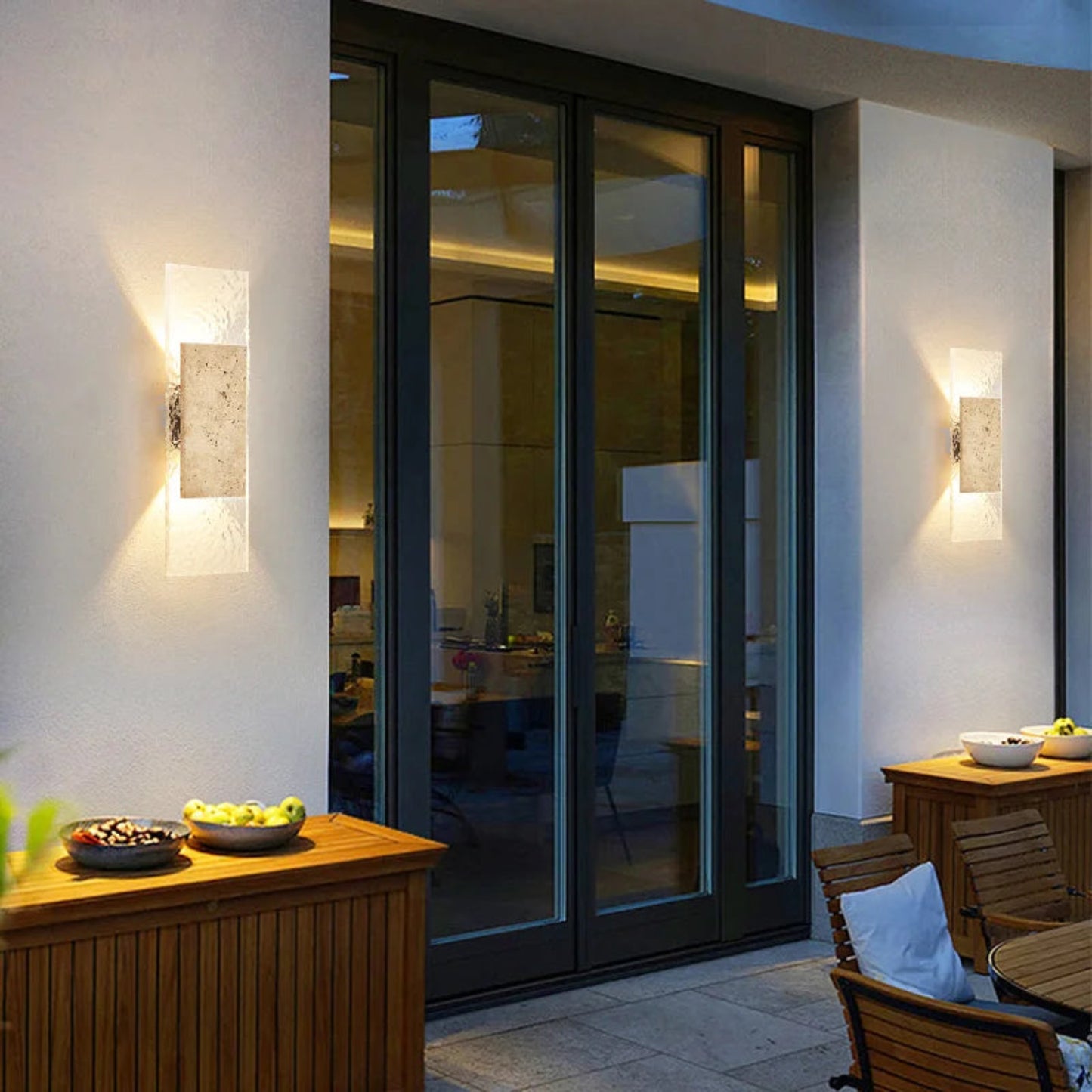 Modern outdoor patio area with glass doors, wooden furniture, and decorative elements.