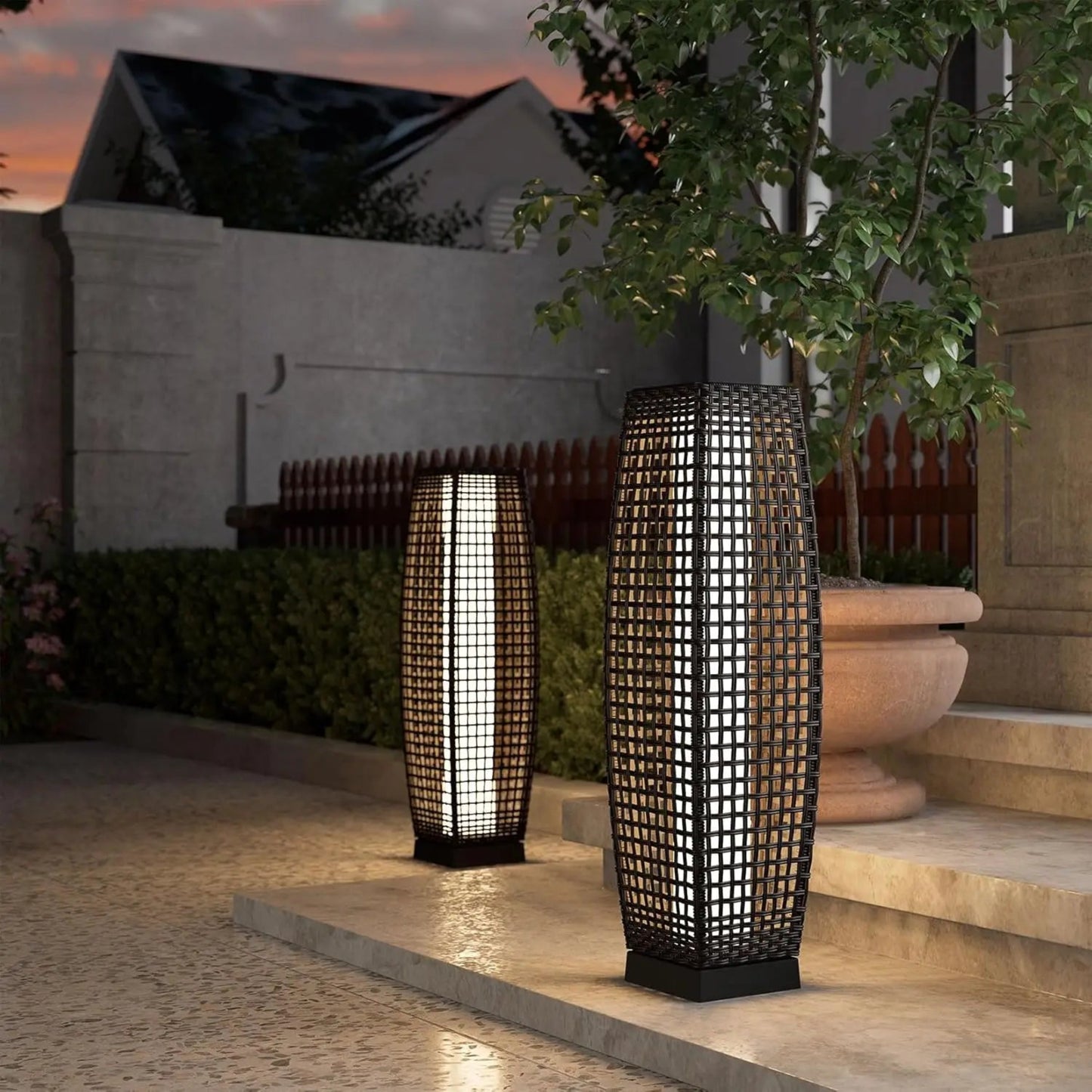 Two outdoor lamps on a patio with a building and tree in the background