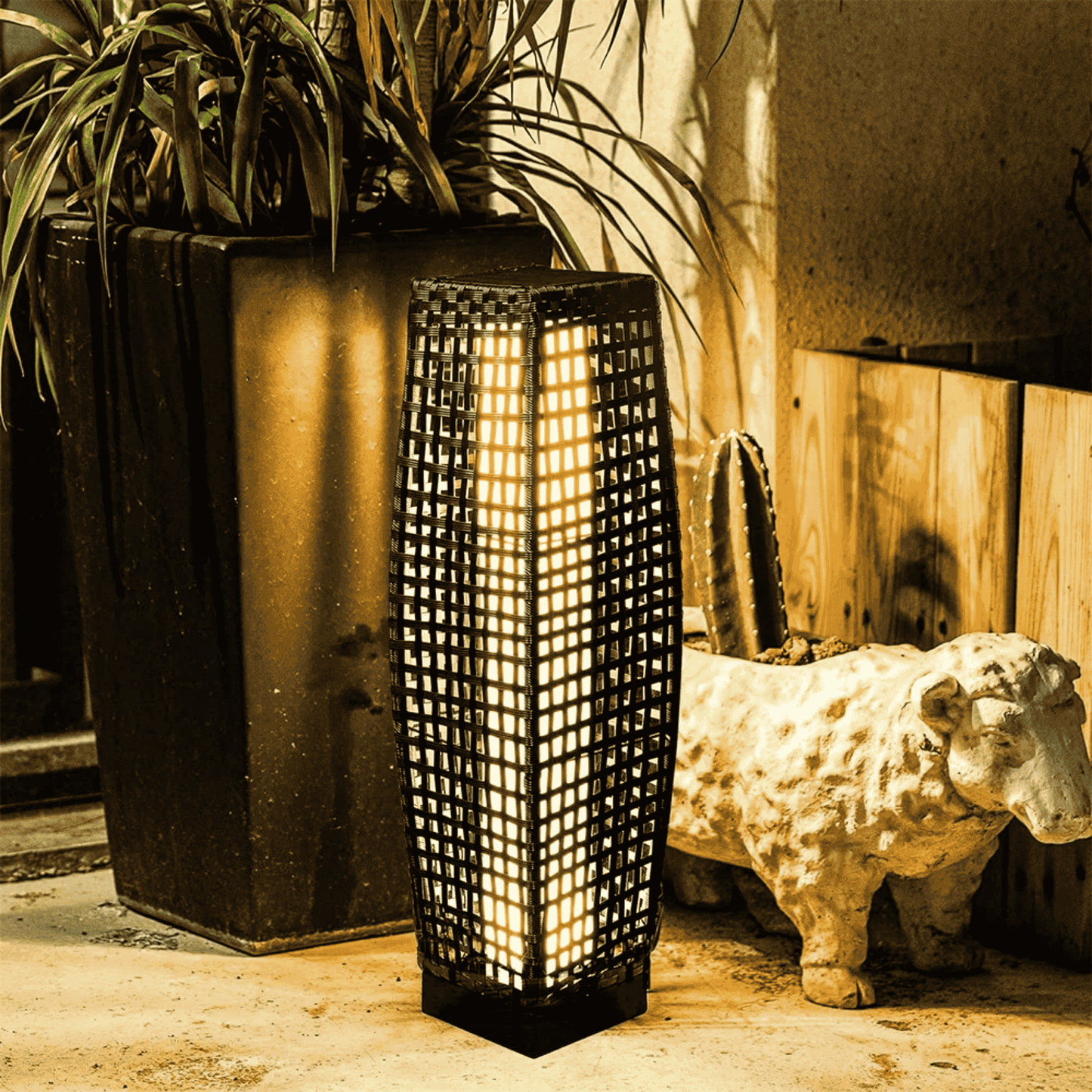 Decorative lamp with a plant and cow statue in the background