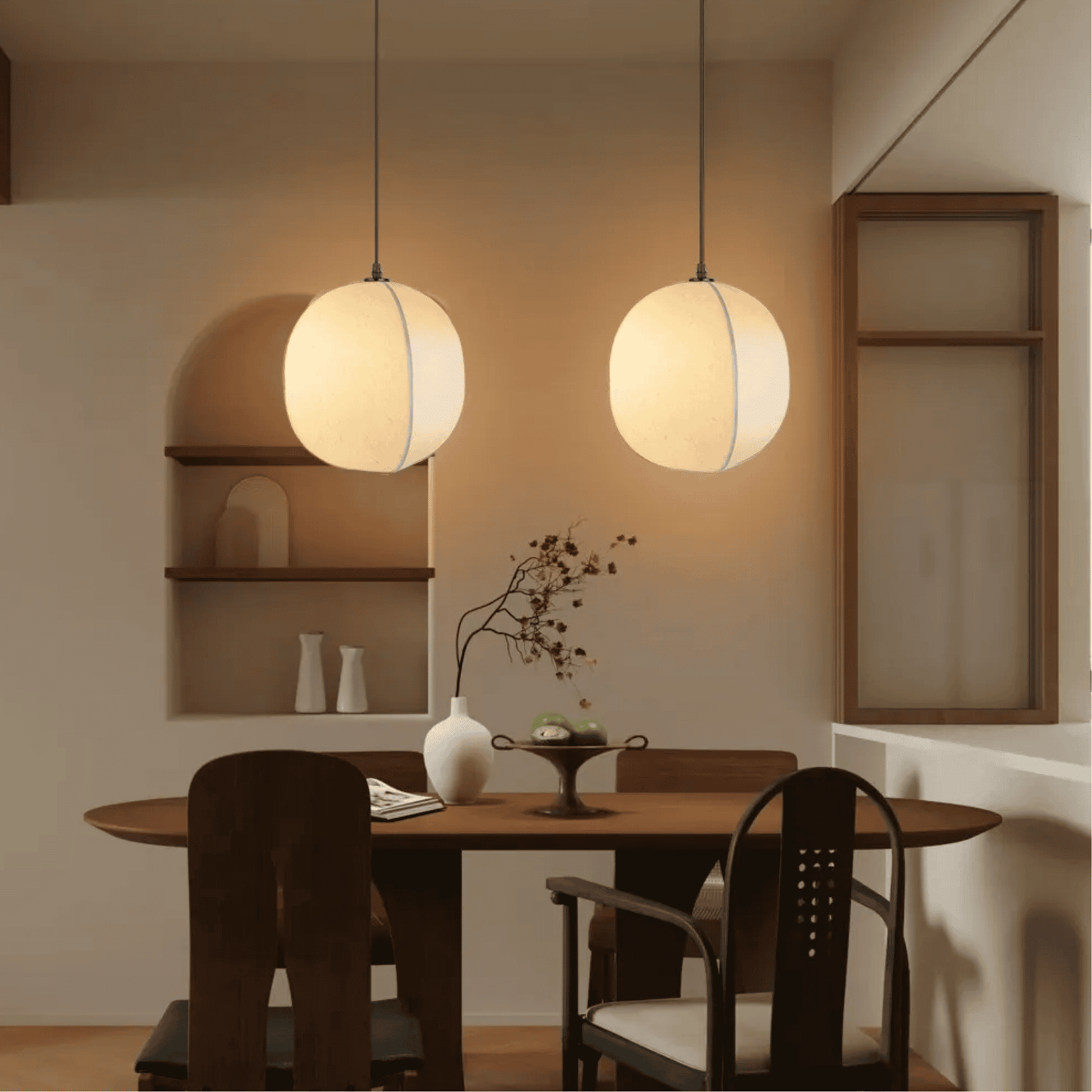 Dining room with round table and chairs, pendant lights, and shelves.