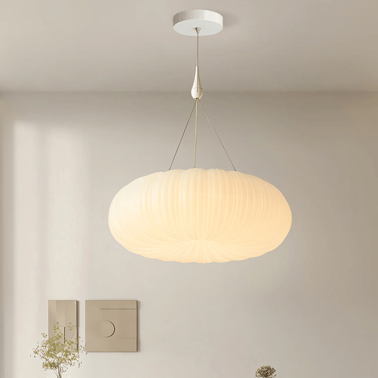 Modern pendant light hanging in a room with neutral walls and minimal decor.