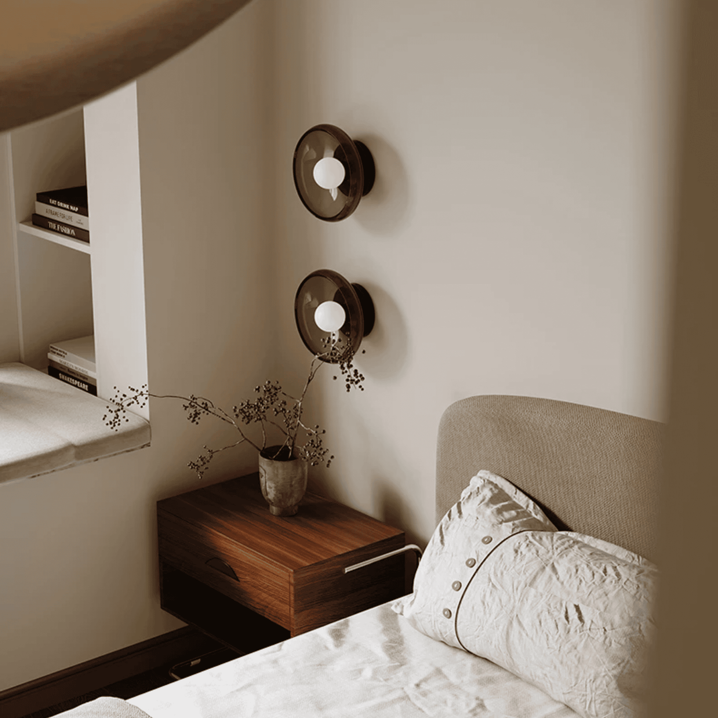 Bedroom with a bed, nightstand, and wall sconces.
