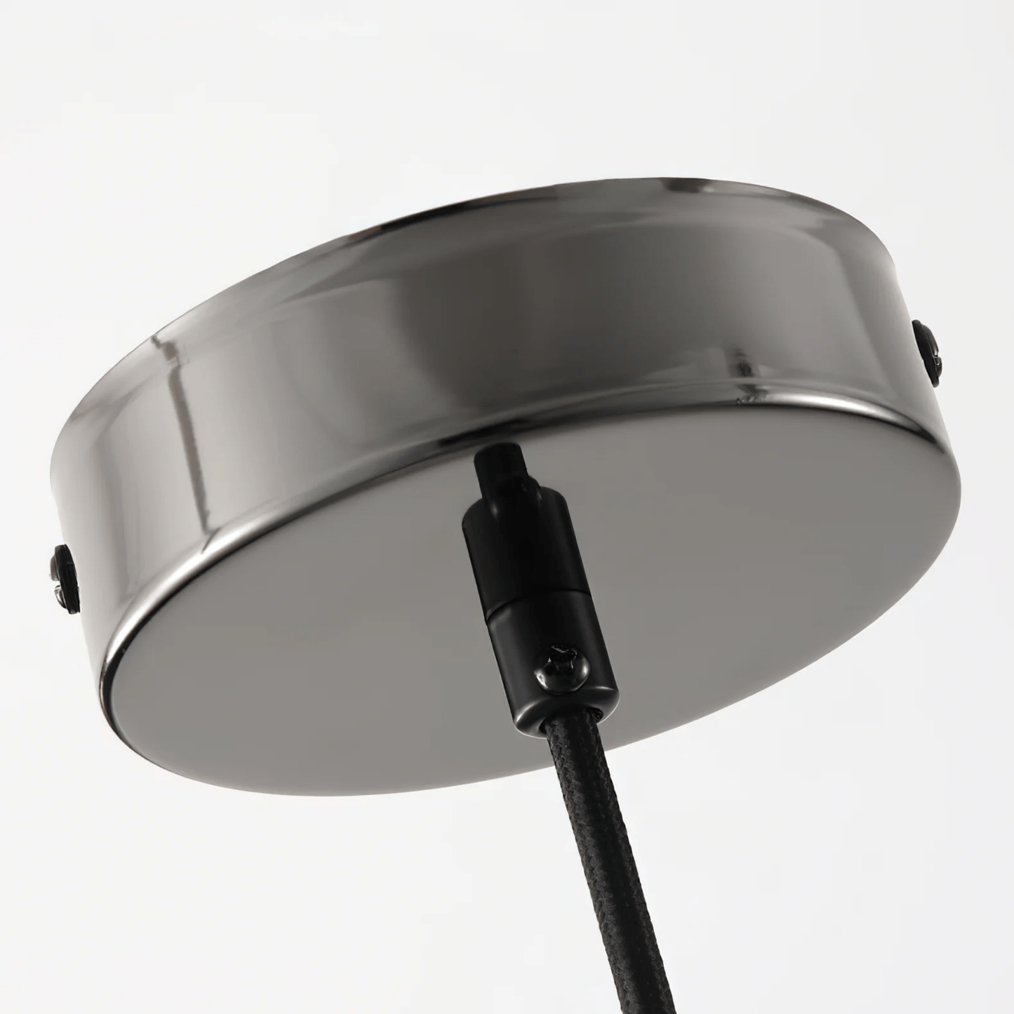 Round metallic object with a black cable on a light gray background