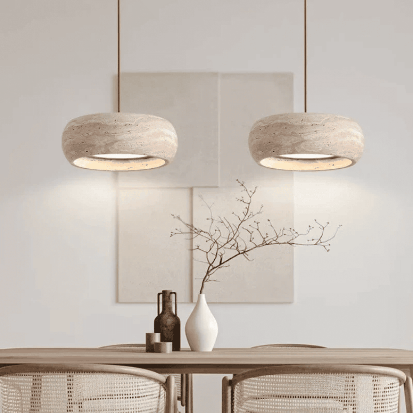 Two pendant lights hanging above a table with decorative items in a room.