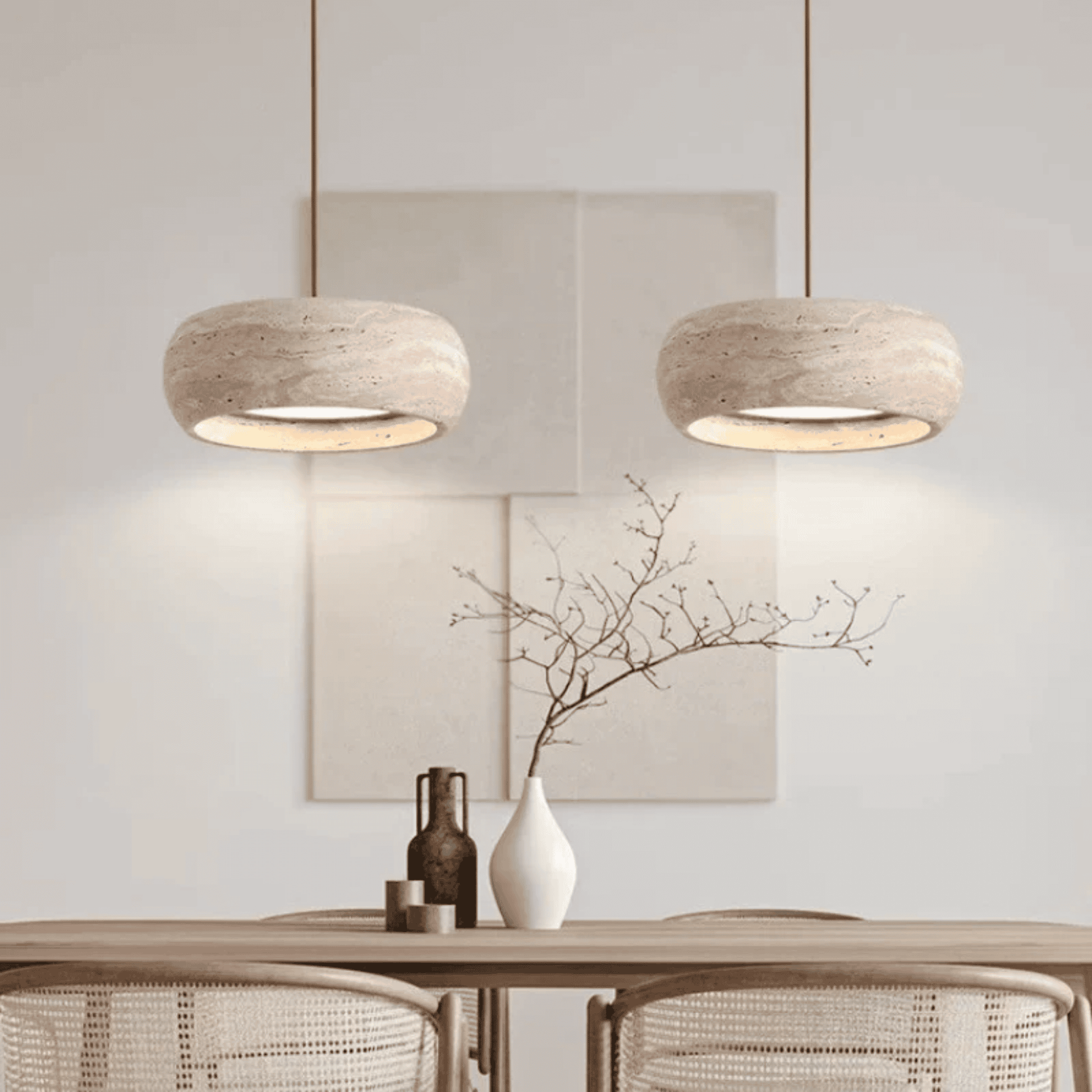 Two pendant lights hanging above a table with decorative items in a room.