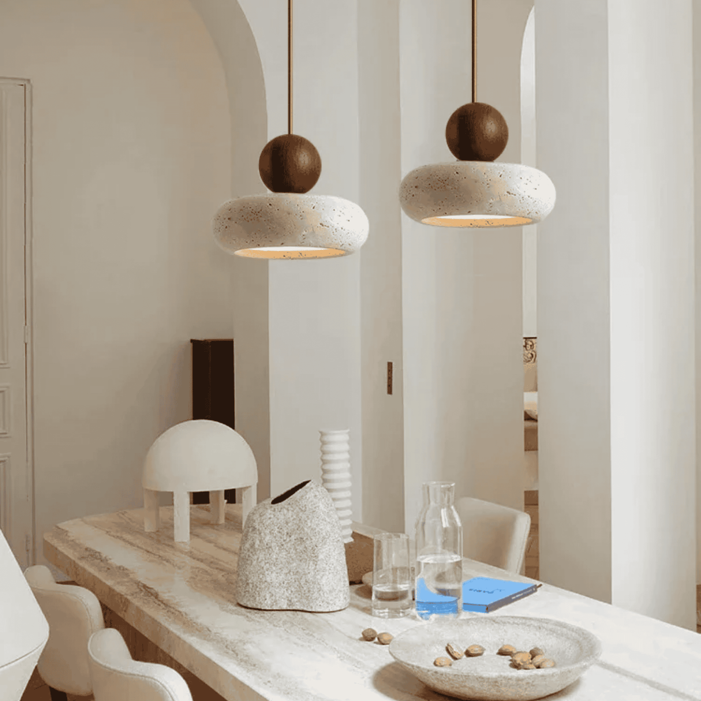 Modern interior with pendant lights, a dining table, and decorative items.