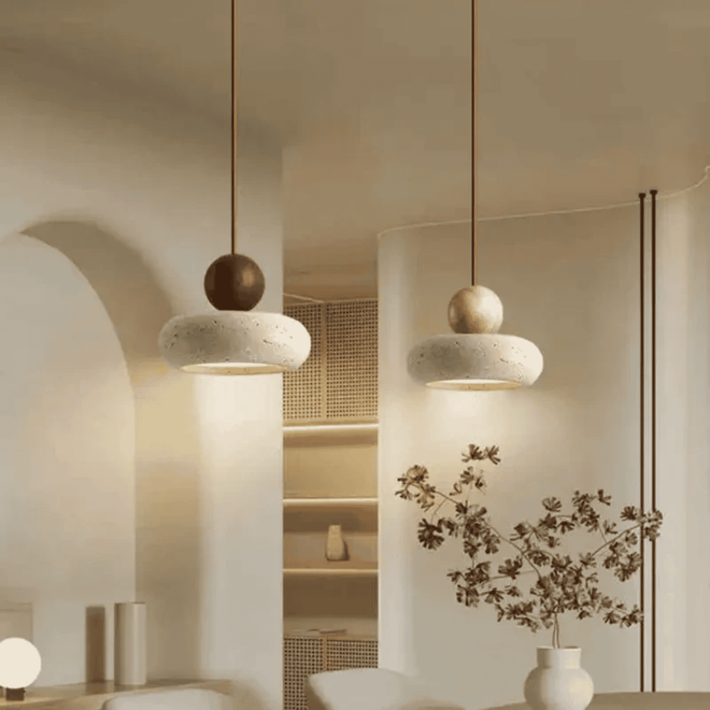Modern pendant lights hanging in a softly lit room with minimal decor.