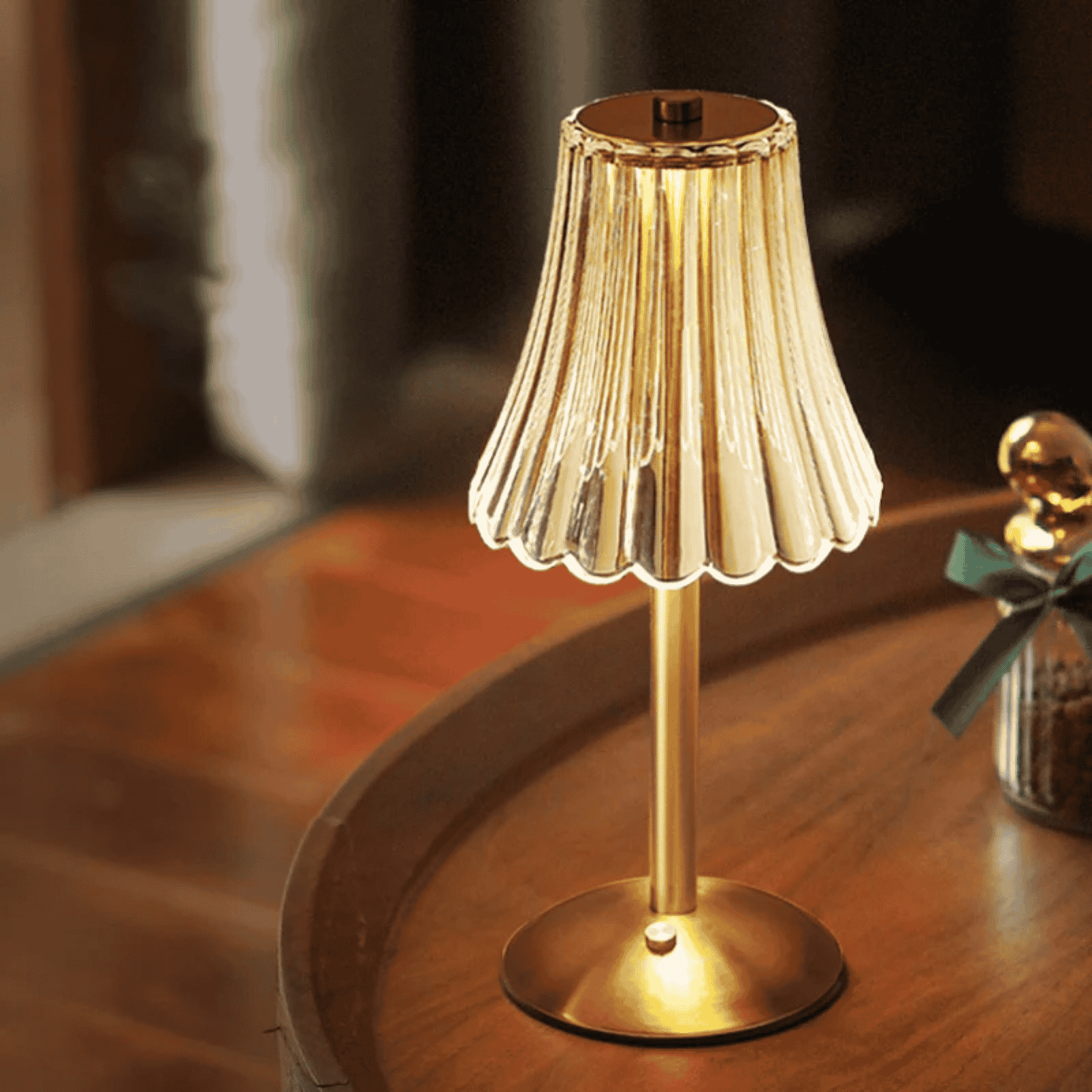 Gold table lamp with pleated shade on a wooden surface
