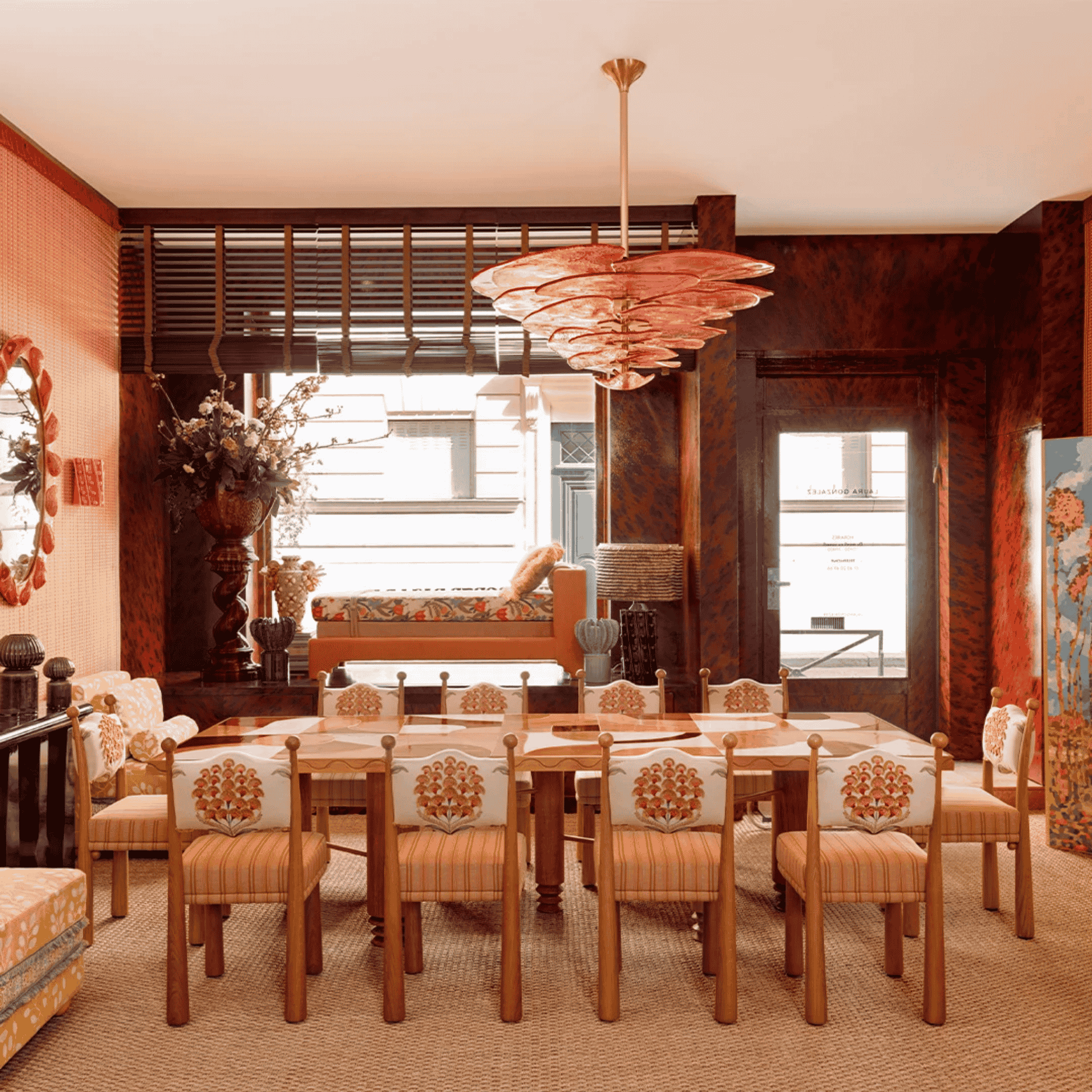 Dining room with wooden table and chairs, chandelier, and large window.