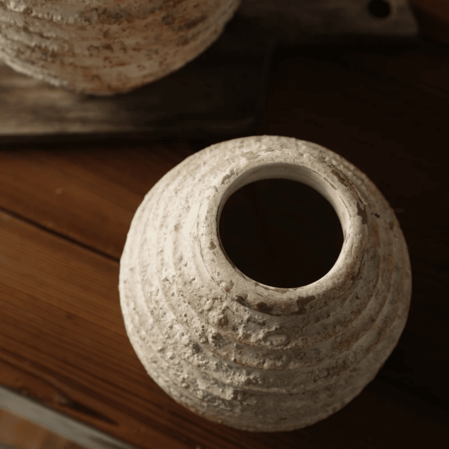 Textured ceramic vase on a wooden surface