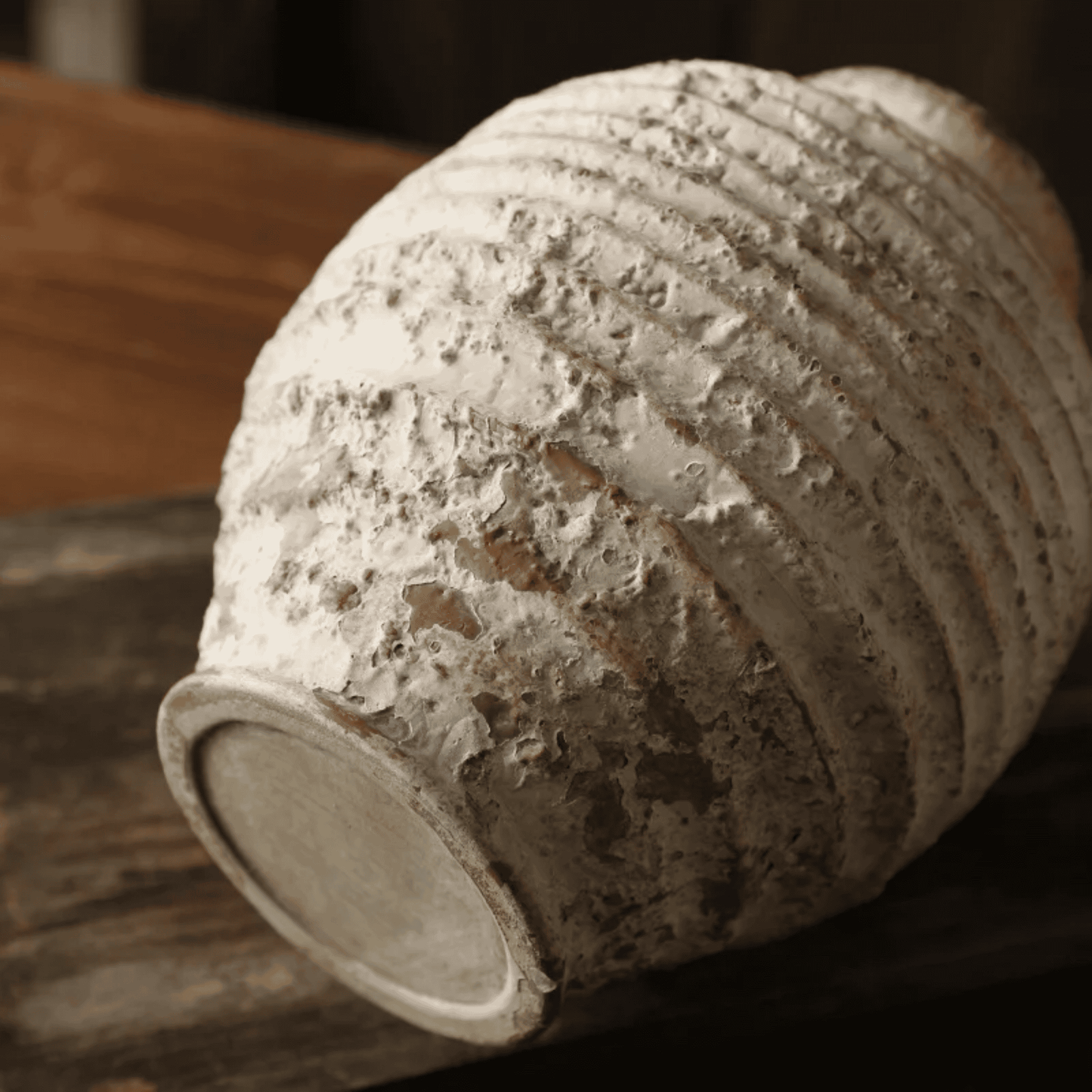 Textured ceramic vase on a wooden surface