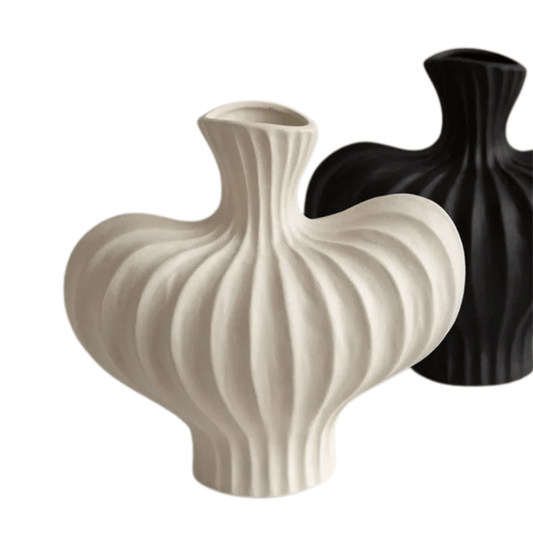 Two ceramic vases, one beige and one black, on a white background