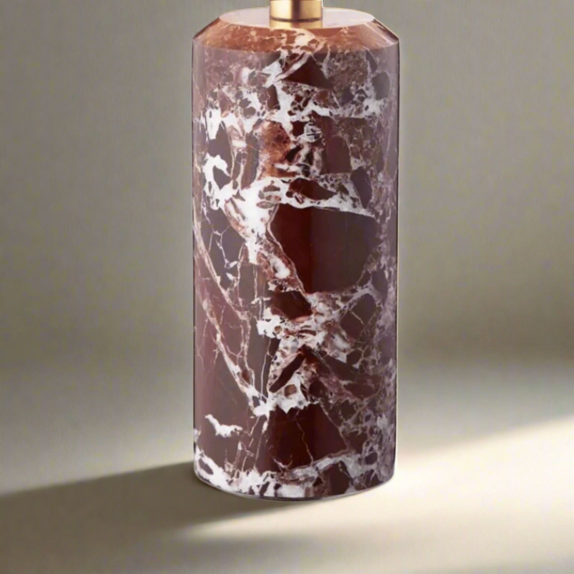 Marble-patterned cylindrical object with a gold accent on a white background