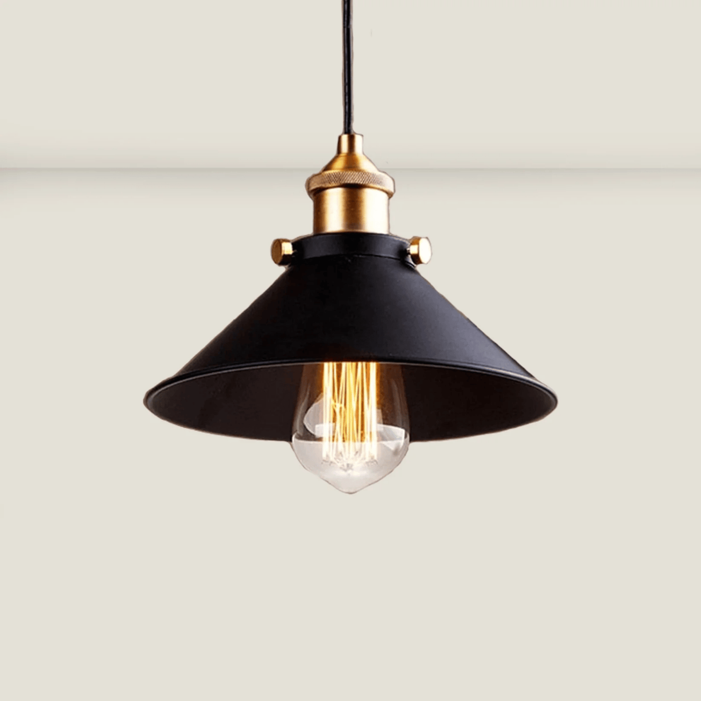 Pendant light with black shade and gold fixture on a neutral background