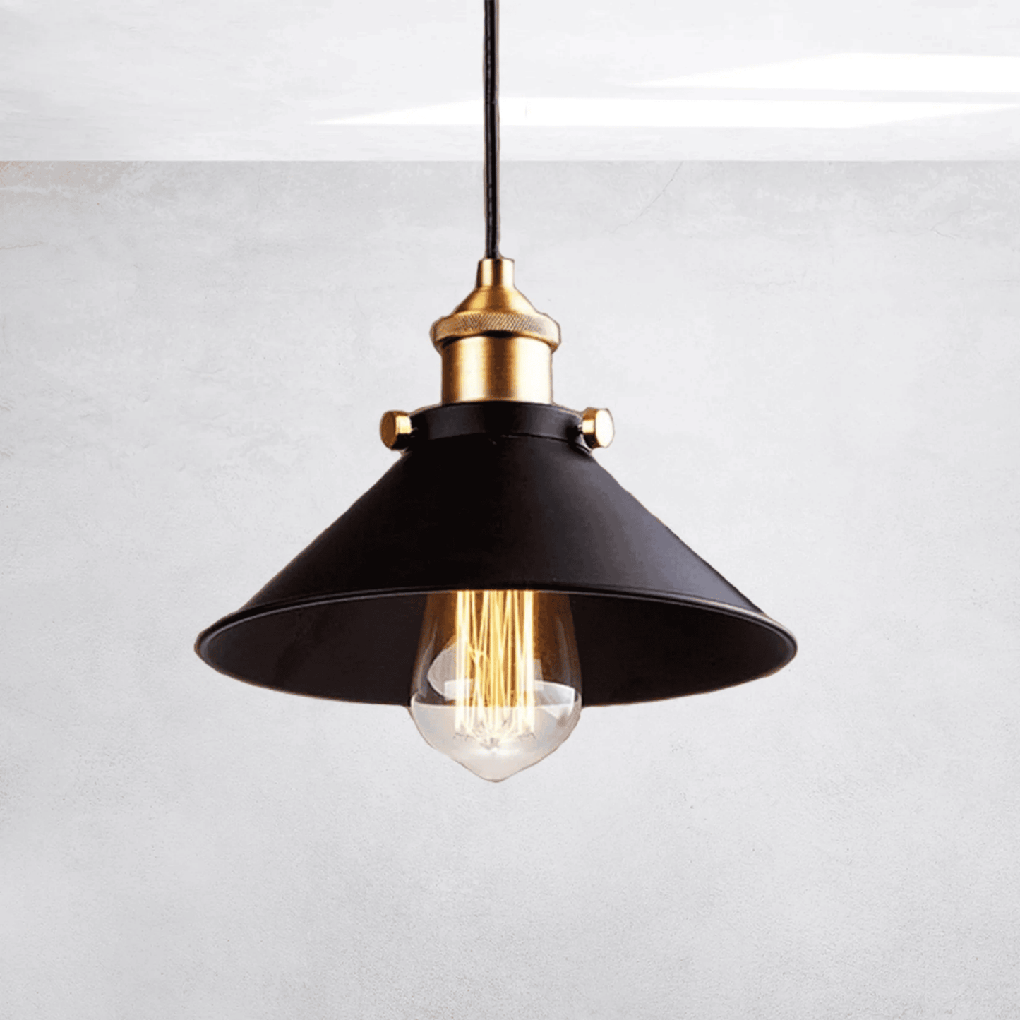 Black pendant light with gold fixture on a white background