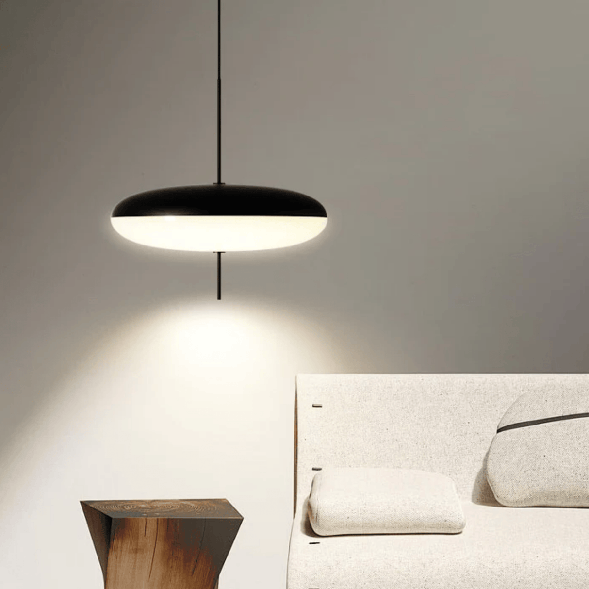 Modern pendant light hanging above a bed in a bedroom setting