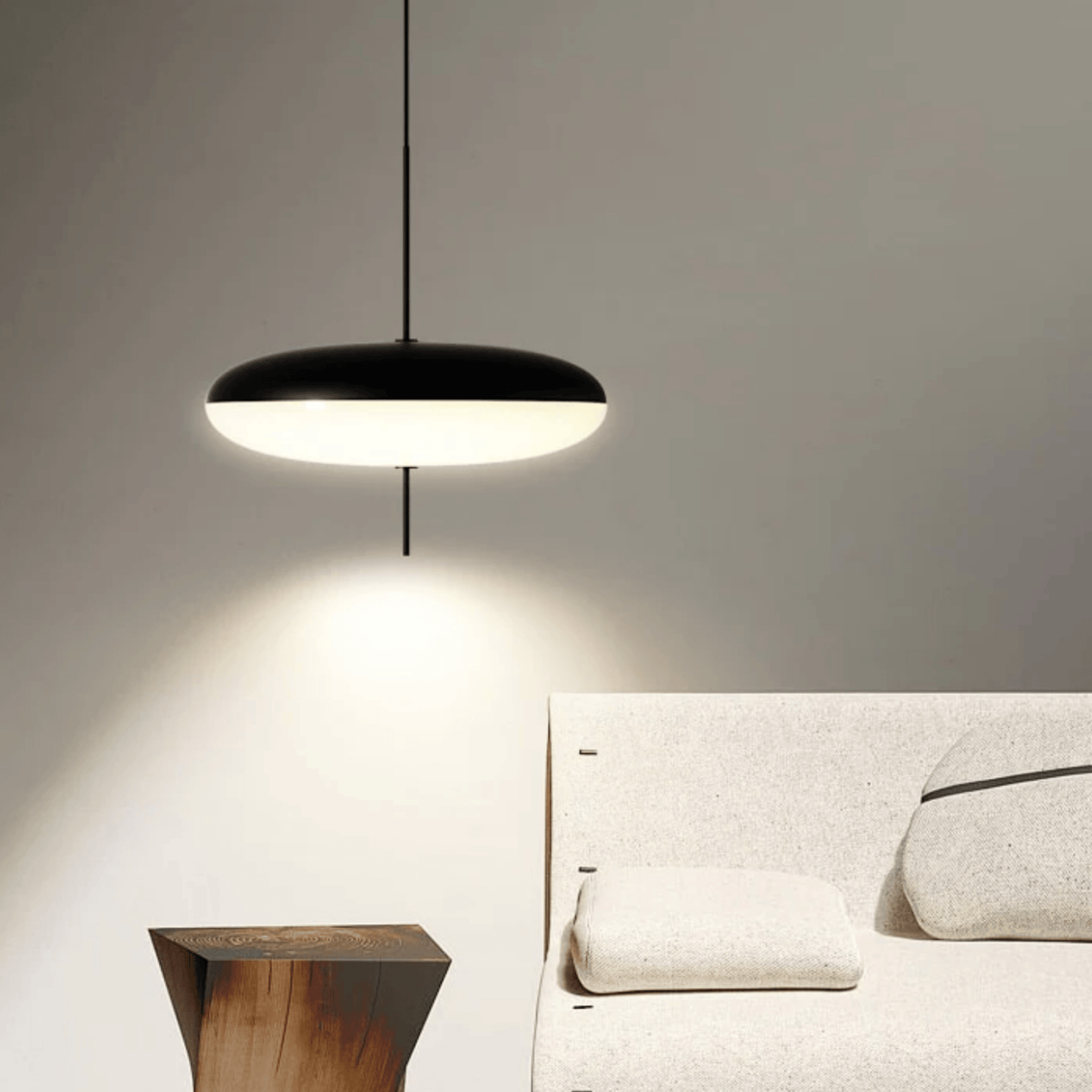 Modern pendant light hanging above a bed in a bedroom setting