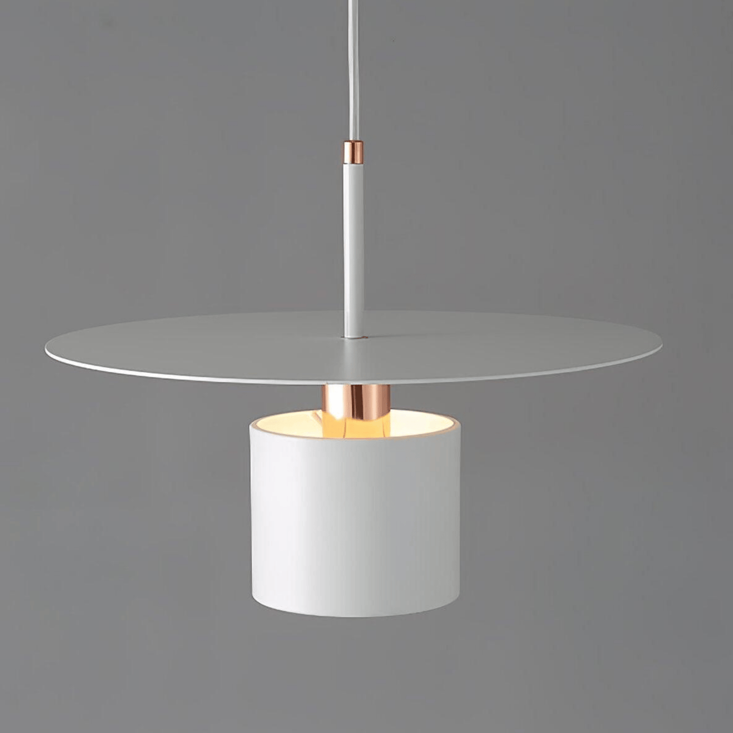 Modern pendant light with white glass shade and copper accents on a gray background