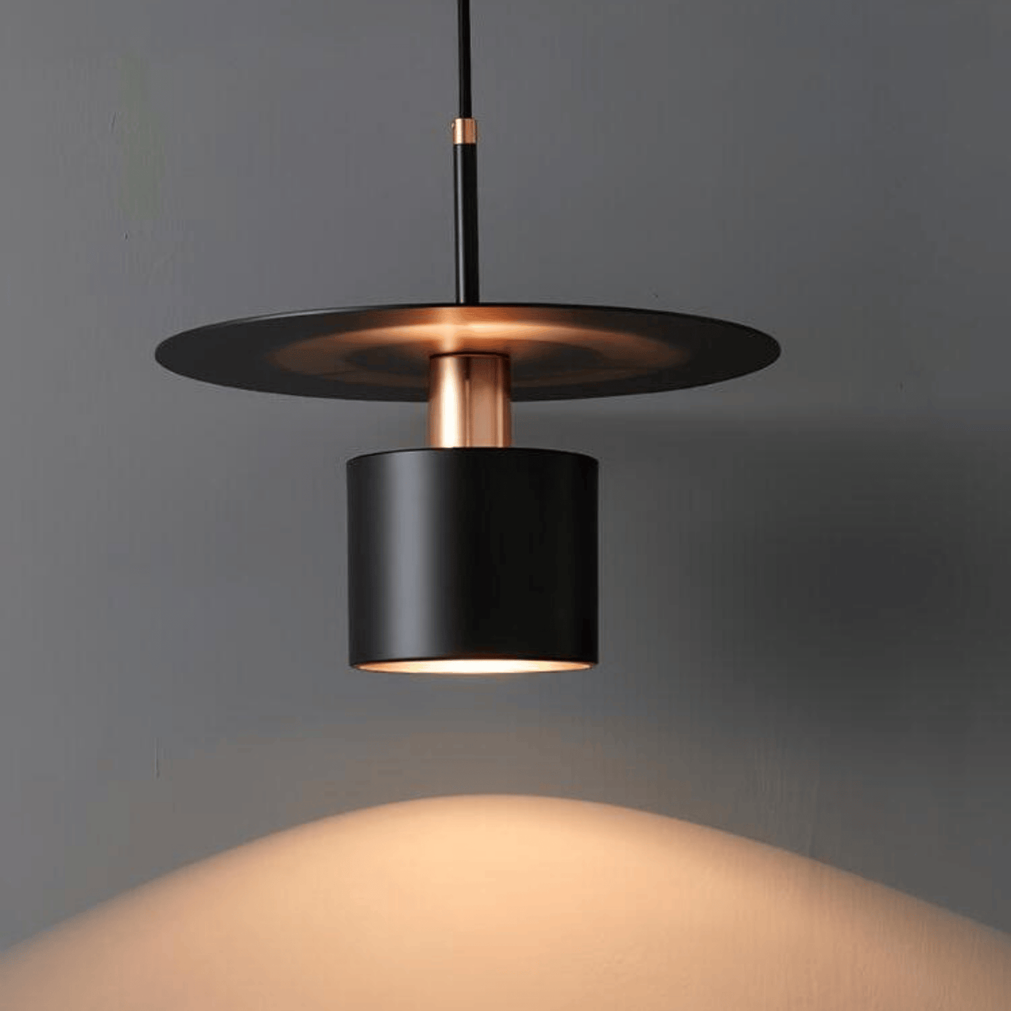 Modern pendant light with black and copper design on a gray background