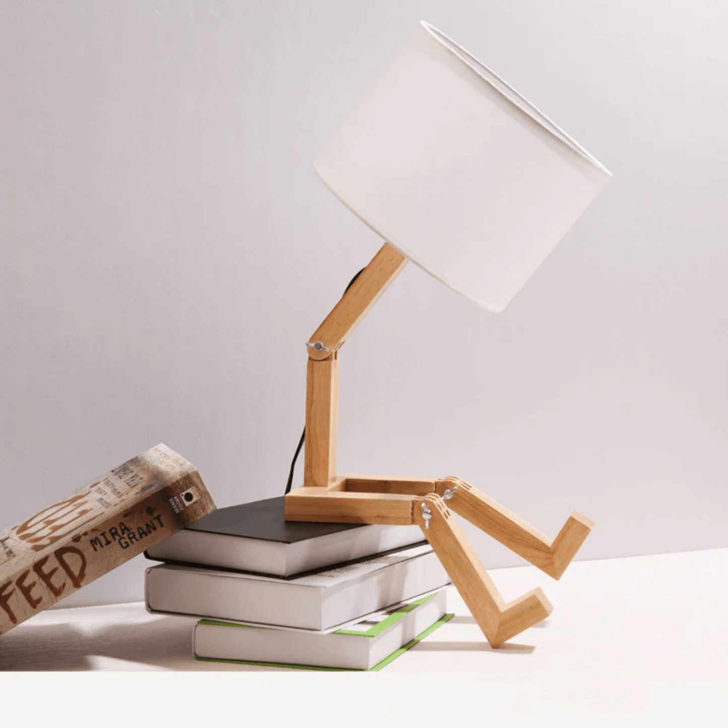 Wooden desk lamp on a stack of books with a white background