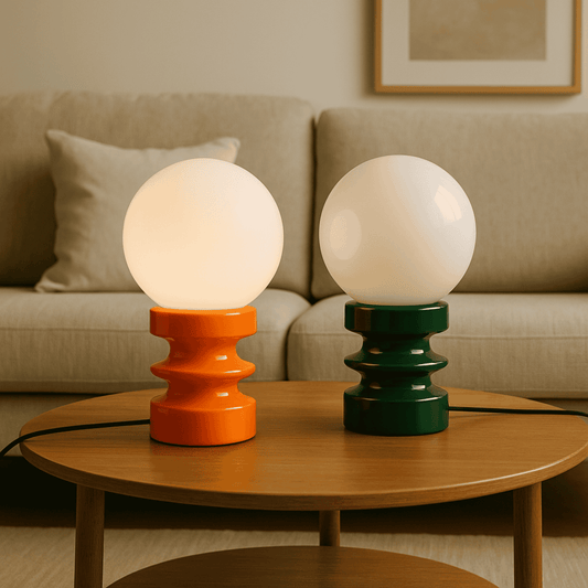 Two spherical table lamps with orange and green bases on a wooden coffee table in a living room setting.