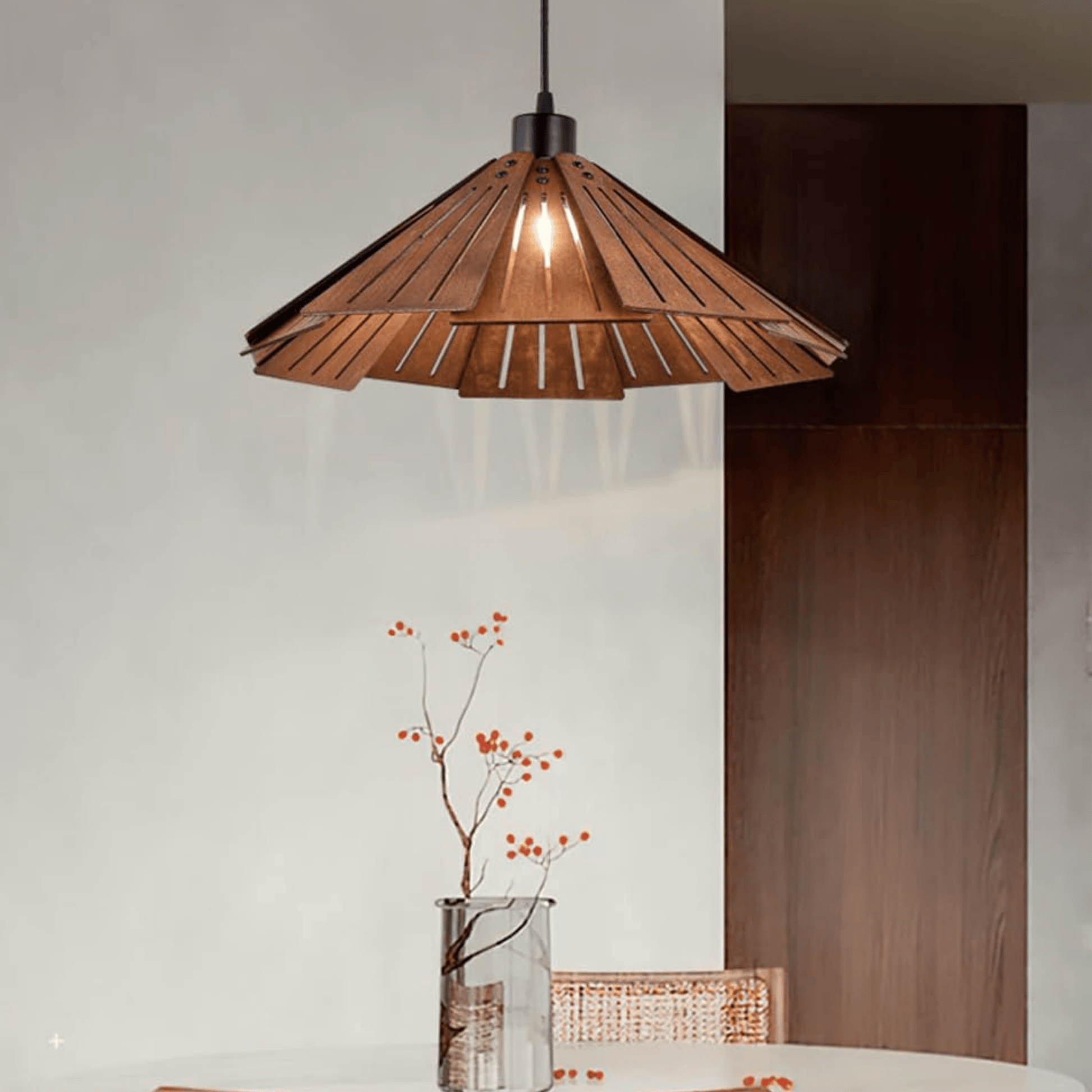 Wooden pendant light fixture hanging in a room with a vase of flowers on a table.