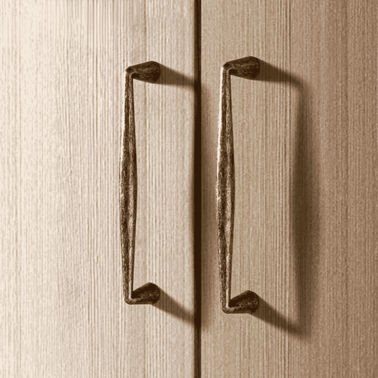 Pair of bronze cabinet handles on a wooden surface
