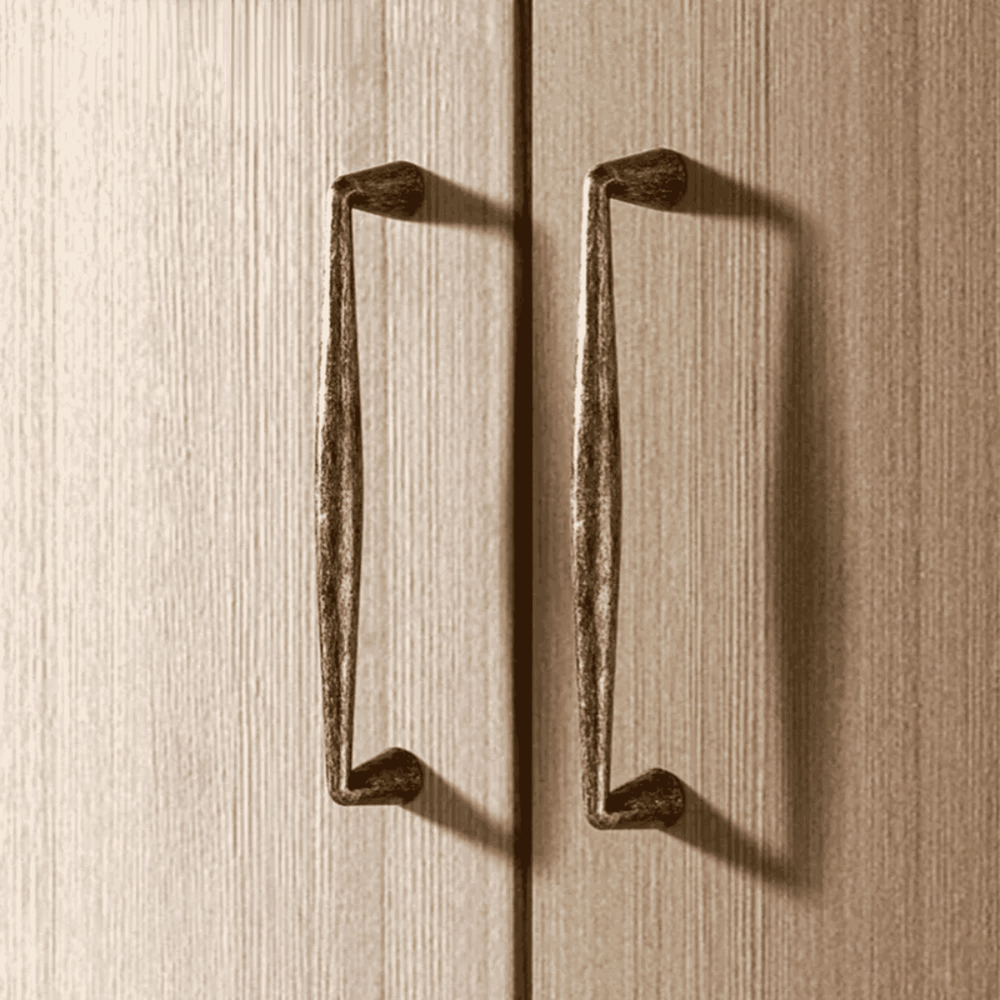 Pair of bronze cabinet handles on a wooden surface