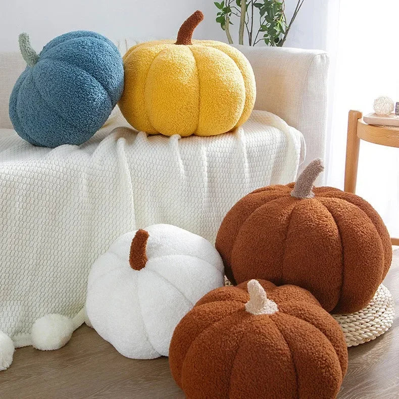 Set of colorful pumpkin-shaped cushions on a sofa and floor.