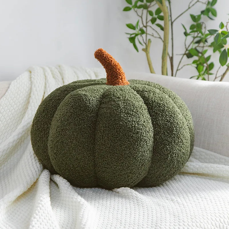 Green textured pumpkin pillow on a white surface with a plant in the background
