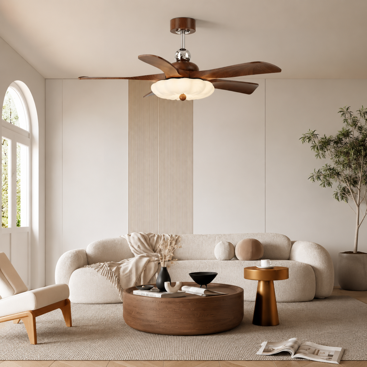 Modern living room with a ceiling fan, sofa, coffee table, and decorative items.