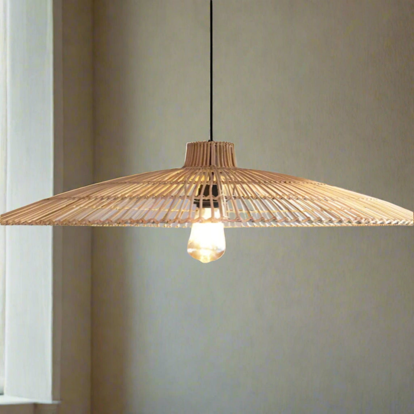 Woven pendant light with a bulb on a gray background