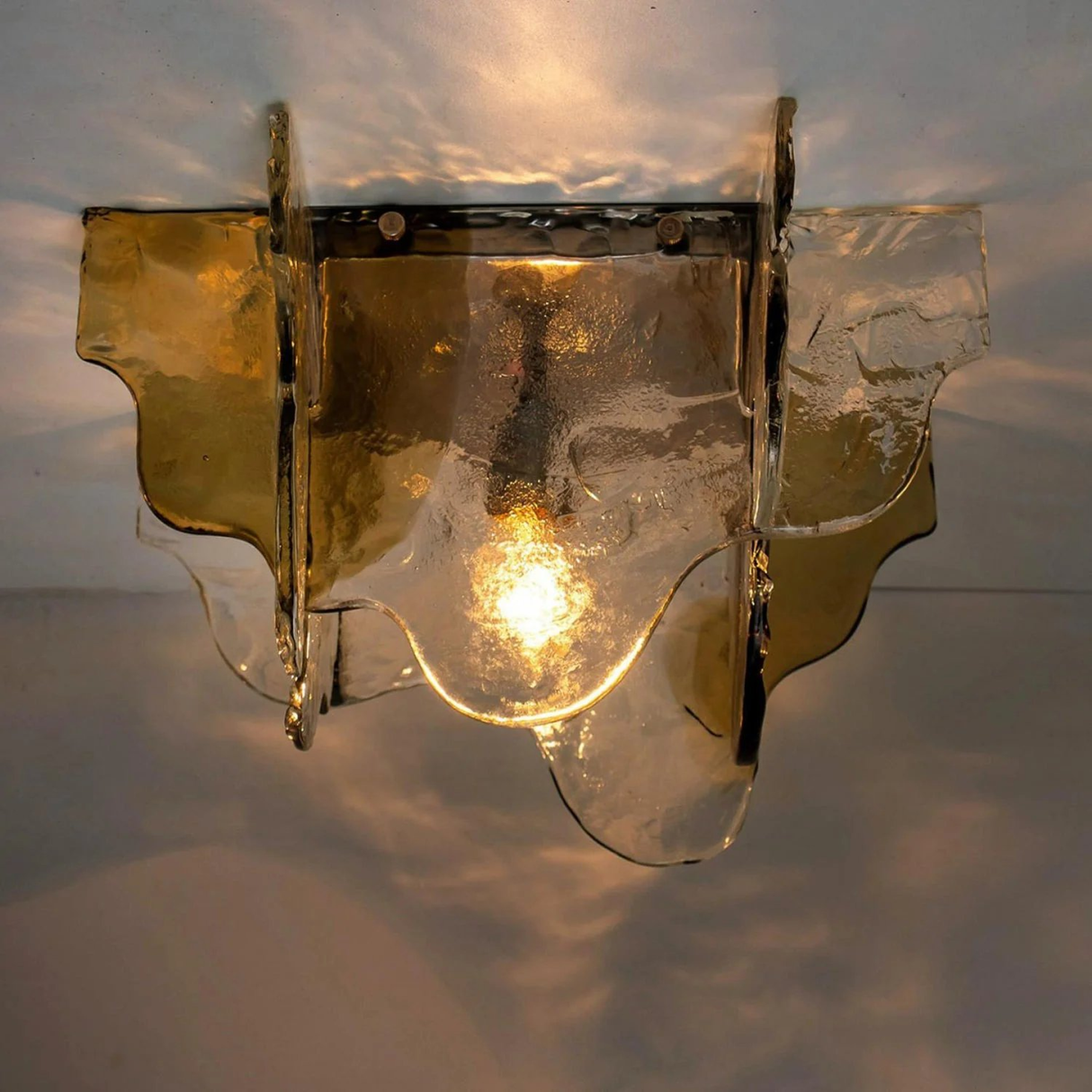 Decorative wall light fixture with glass shade on a neutral background