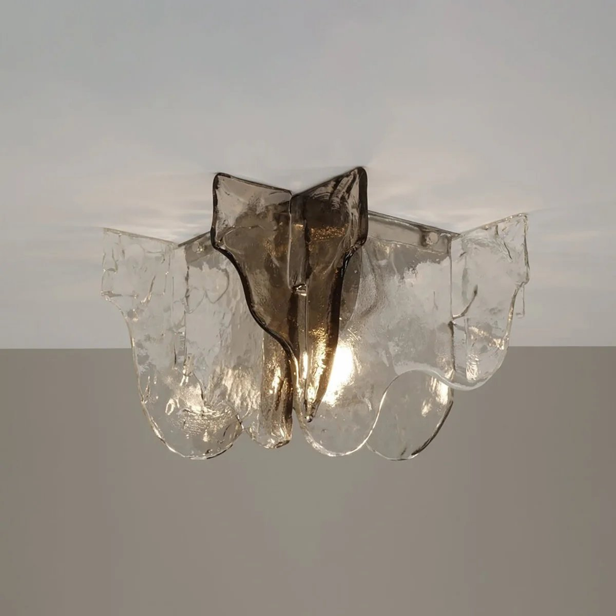 Ceiling light fixture with glass shade on a plain background