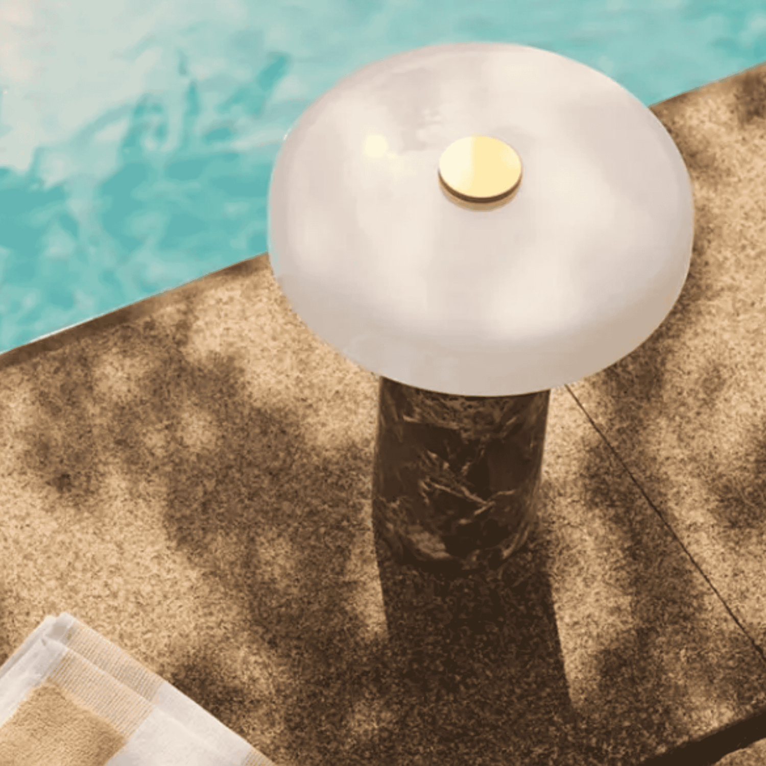 Ceramic vase with white top by a pool