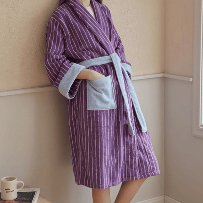 Person wearing a purple and gray striped robe in a room.