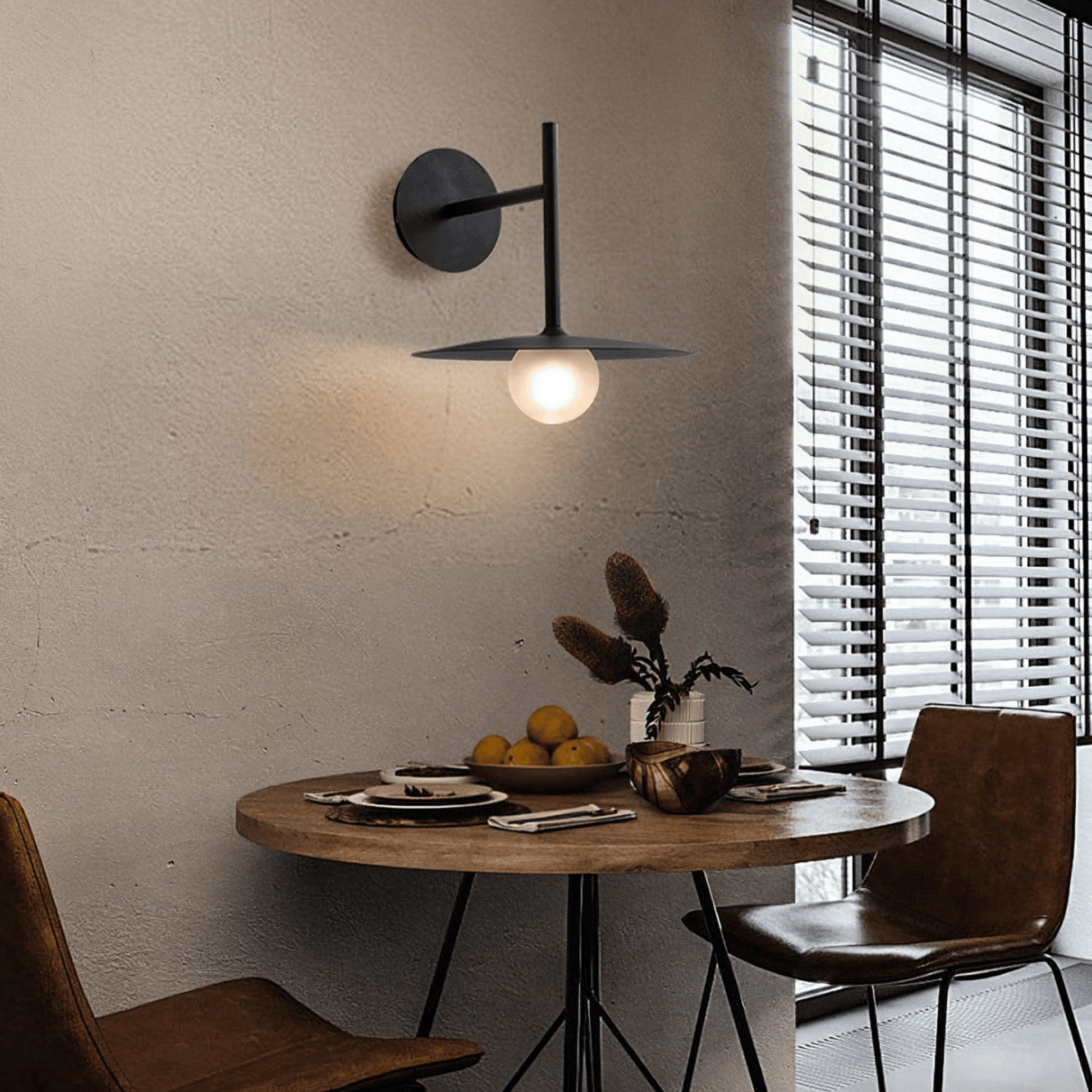 Modern interior with a round wooden table, chairs, and a wall-mounted lamp.