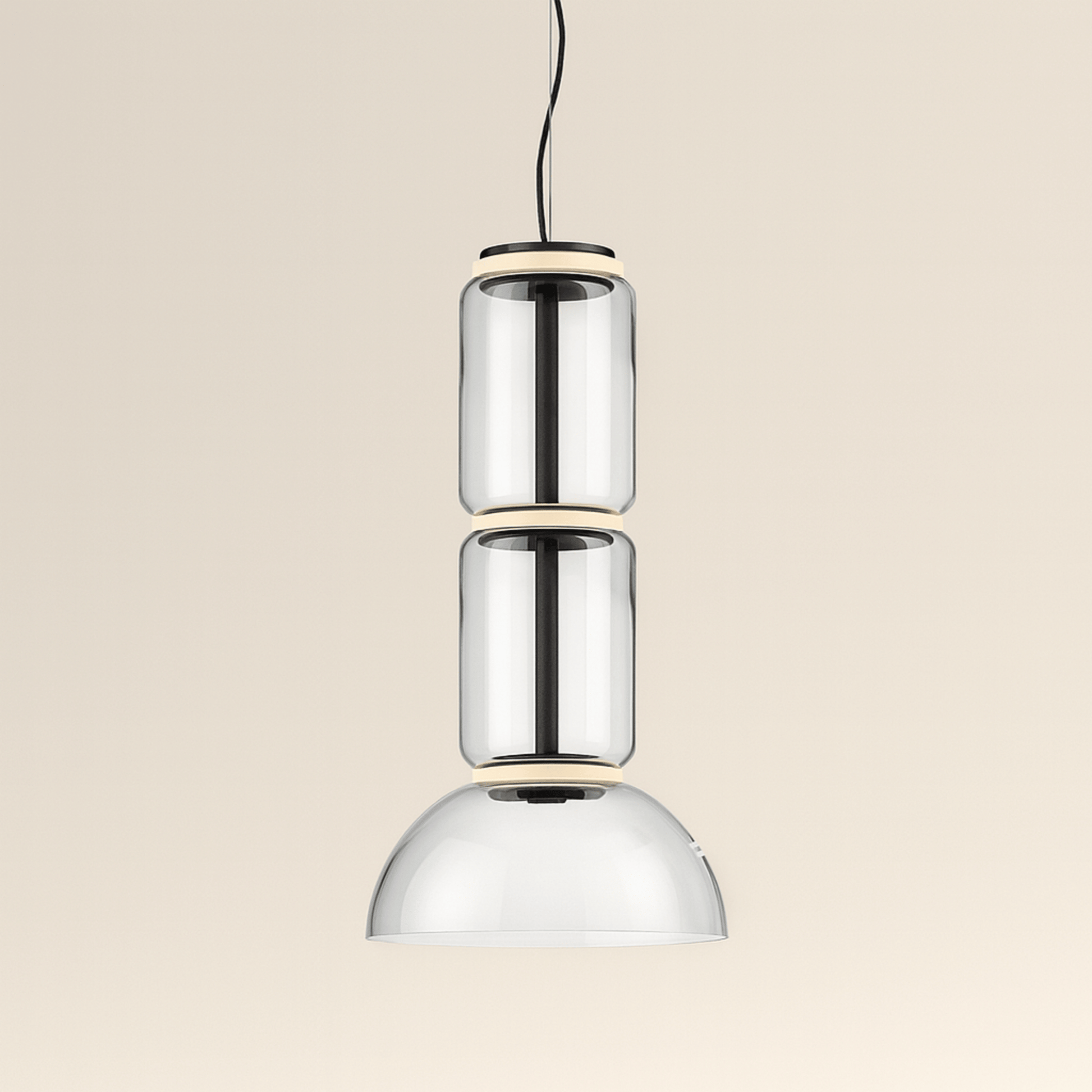 Modern pendant light with three cylindrical glass shades on a beige background