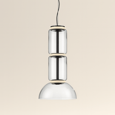 Modern pendant light with three cylindrical glass shades on a beige background