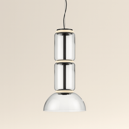 Modern pendant light with three cylindrical glass shades on a beige background