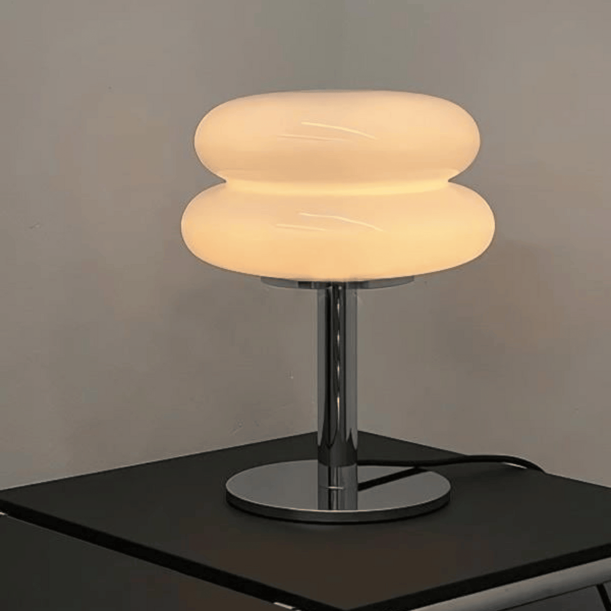 Modern table lamp with a unique design on a dark surface against a gray background