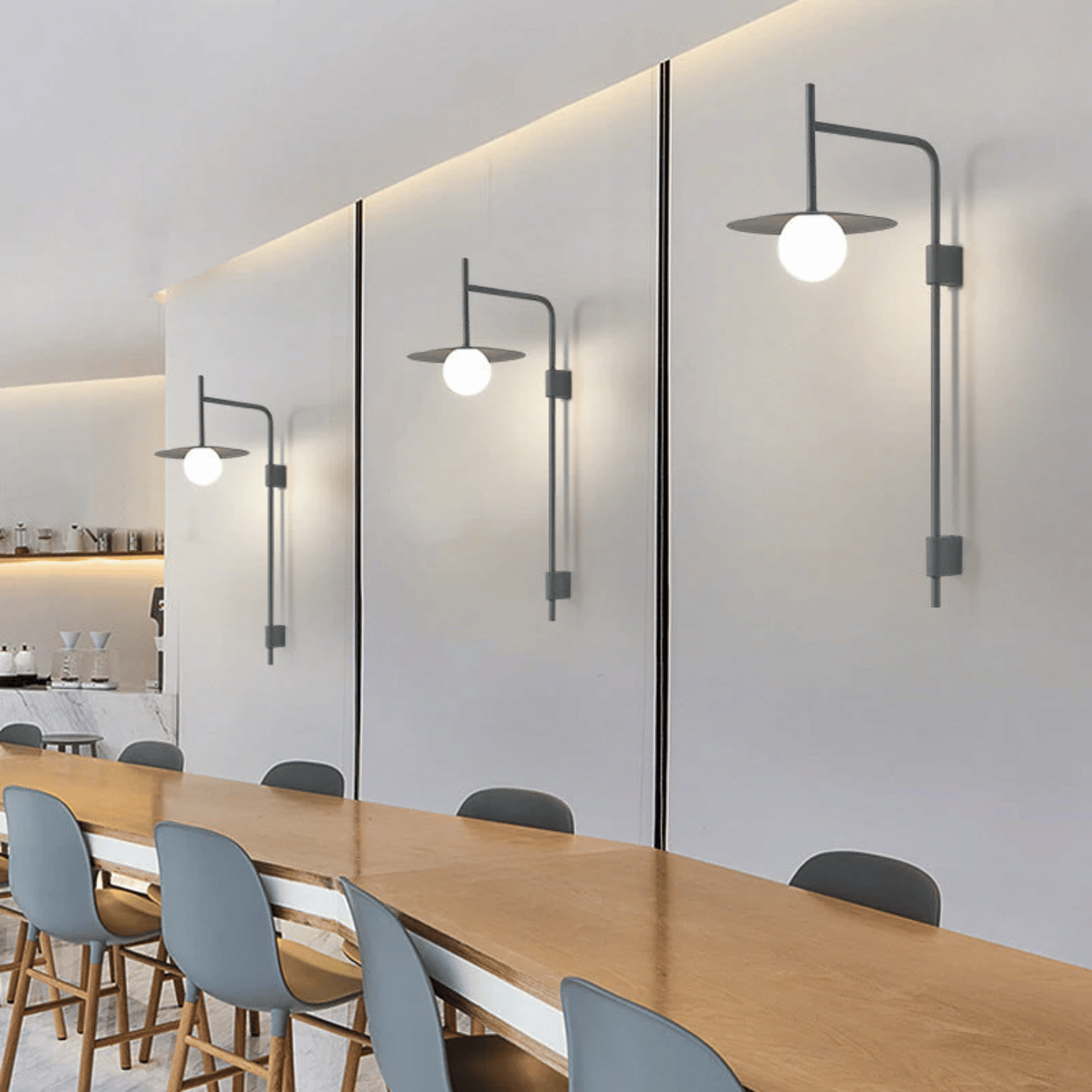 Modern conference room with long wooden table and gray chairs, featuring wall-mounted lights.