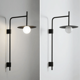 Modern wall-mounted light fixture with a black frame and white bulb on a plain background.