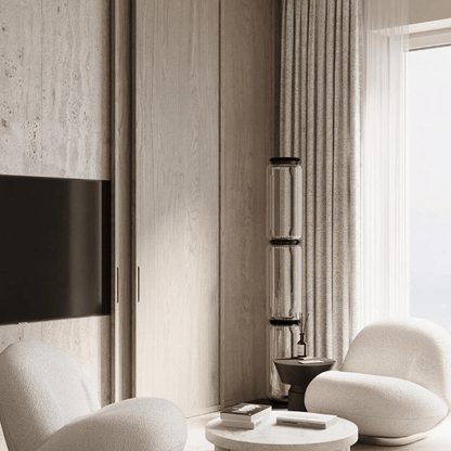 Modern living room with neutral tones, white chairs, and a TV mounted on the wall.