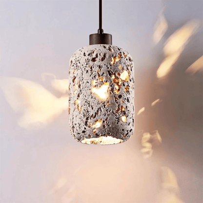 Cement pendant light with a textured design on a blurred background